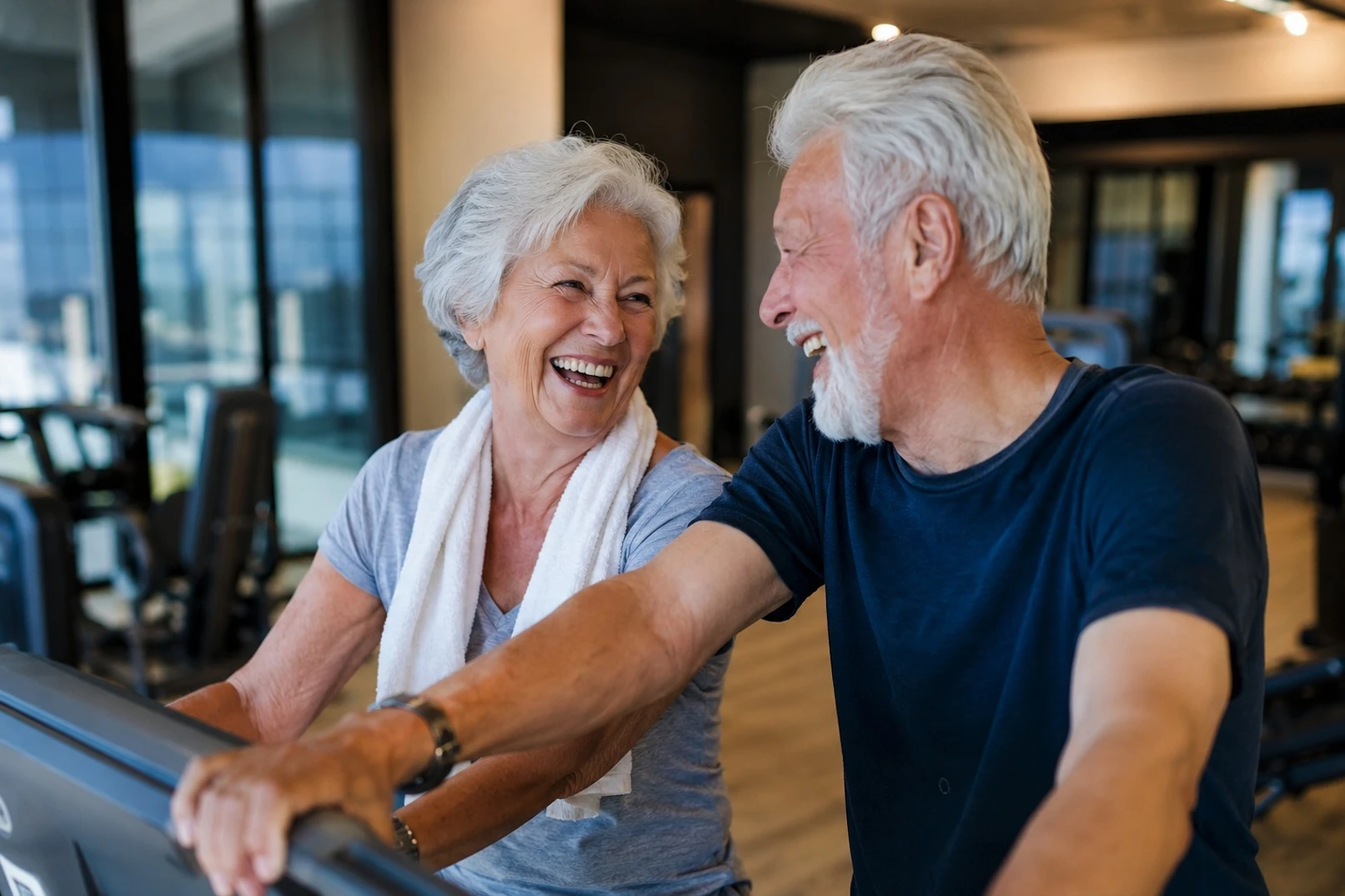 Älteres Paar trainiert gemeinsam und lacht im Fitnessbereich von AMILU in Oberursel